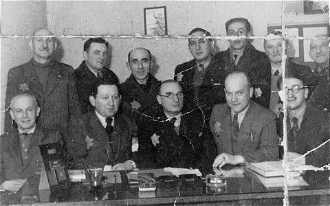 Group portrait of members of the Jewish council in an office in the Lodz ghetto